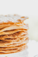 Baked crumpets cakes made of puff pastry for layer cake on a glass stand. Semi-finished product for cake.