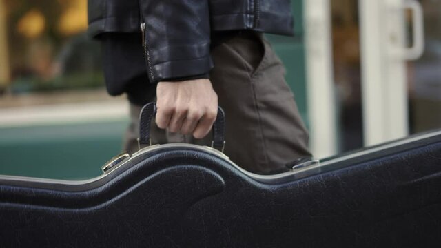 Man Carrying Guitar Case In The City