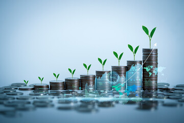 Stacking of coins with plants growing on top for financial and business background. Savings and...