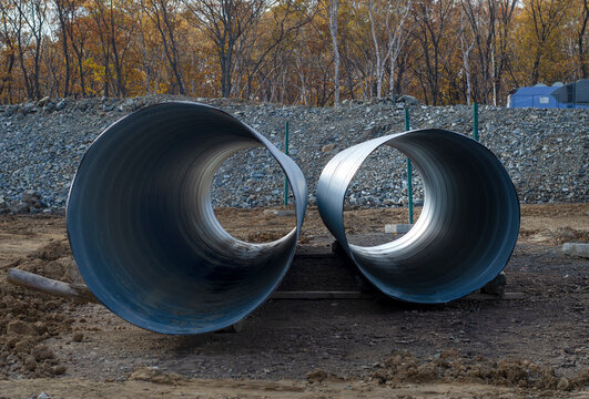 Large diameter metal pipes at a construction site.