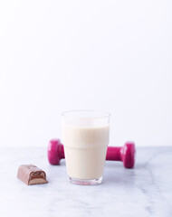 Banana coconut smoothie and protein bar on bright stone background. Soft focus. Copy space.	