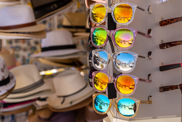 Fototapeta na wymiar Colorful sunglasses on a stand. Summer eyeglasses, fashion collection. Summer in Greece