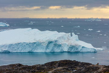 landscape at the mouth of the Ilulissat icefjord in west Greenland: huge icebergs floating in the...