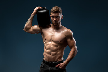 Fototapeta na wymiar Waist up portrait view of the sporty man holding bottle with protein beverage and looking to the camera. Proper nutrition concept. Stock photo