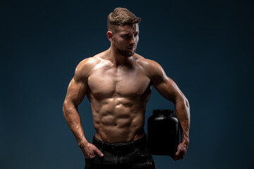 Fototapeta na wymiar High quality photo of the muscular bodybuilder holding a pack of protein powder isolated on black background
