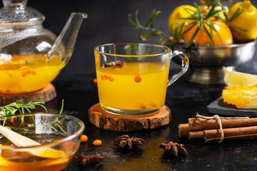 Mug and tea pot with sea buckthorn beverage made with honey, orange, lemon, cinnamon. anise stars 