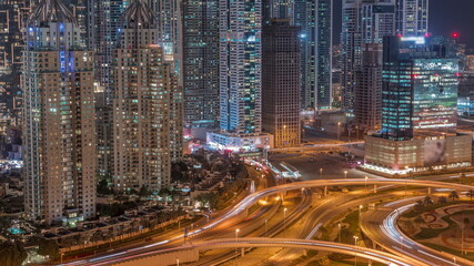 Obraz na płótnie Canvas Aerial view on Dubai Marina with big highway intersection night timelapse and skyscrapers around, UAE