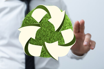 hand holding green recycle symbol