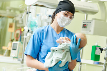 Newborn baby in hospital at neonatal resuscitation center with nurse - 472864763