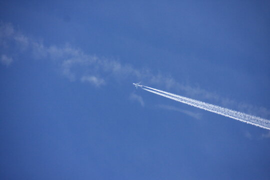 Un avion de ligne qui vol dans le ciel avec des traînées de condensation 