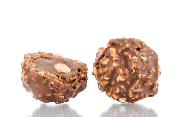 One whole and half of chocolate candy with nuts, close-up, isolated on white.