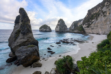 Fototapeta na wymiar Scenery of sunny day with sand beach, turquoise ocean and mountains. View of Diamond beach, Nusa Penida, Bali island, Indonesia. Wallpaper background. Natural scenery. Romantic relax place. Waves.