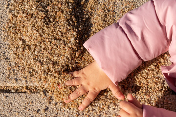 children's hand takes a handful of sand