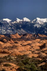 USA, Utah, Arches National Park. Petrified sand dunes below snow-covered La Sal Mountains.