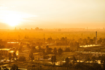 Obraz premium Cityscape with sunset in big city, industrial buildings under dramatic sunset sky