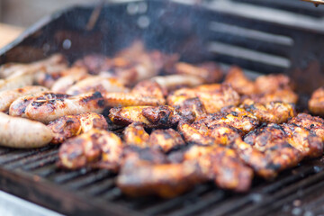 Close up of chicken wings and sausages on the BBQ