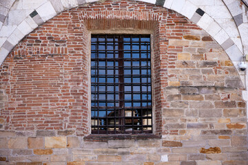 Window with bars. Old building facade with a window with bars