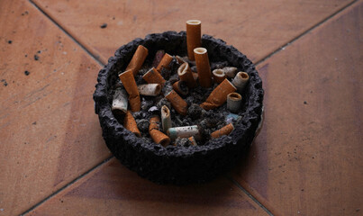 there is an ashtray full of cigarette butts on the windowsill