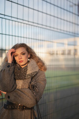 Fototapeta premium Wunderbare Schöne Frau mit Blondem Haar und Grauen Mantel in der Winter Zeit in Berlin