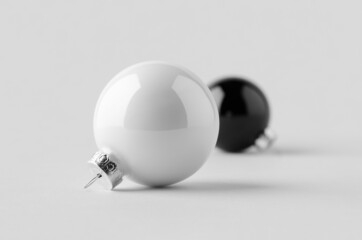 White and black glossy Christmas balls mockup on a seamless grey background.