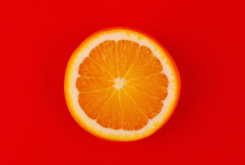Round orange slice on red background