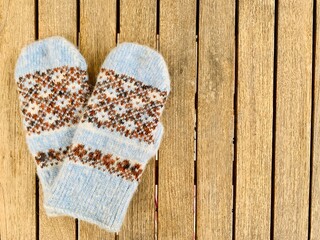 blue mittens on wooden background copy space