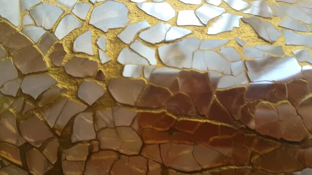 A decorative jar vase made of golden glass fragments reflects light with an elegant shimmer, creating a luxurious, artistic, and warm atmosphere suitable for modern interior visuals.