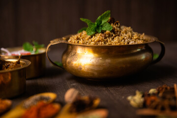  Spicy chicken biryani served in a brass bowl with indian spices 