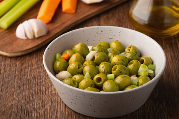 Italian green olive salad and ingredients in the background