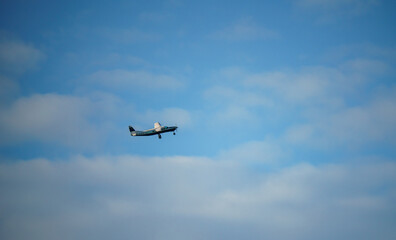 Fototapeta na wymiar Cessna 208b Grand Caravan G-CPSS light aircraft climbing in a blue and white cloud sky