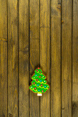 Gingerbread in shape of Christmas tree. Cookie on wooden background. Holiday concept with copy space.