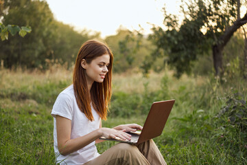 women outdoors in field with laptop leisure technology freedom