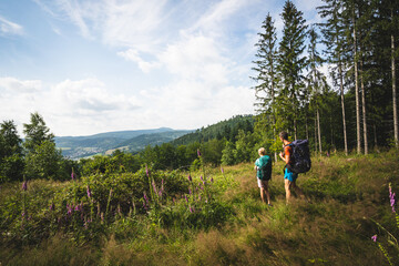 Fototapeta na wymiar Vater und Tochter wandern zusammen und geniessen die Aussicht im Sommer, bei Floh-Seligenthal im Thüringer Wald