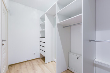 The interior of an empty dressing room is a lot of white shelves