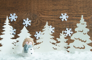 A snowman on the background of a snowy forest.