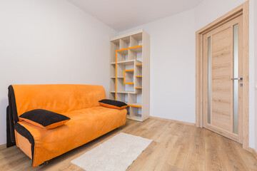 Interior of a room with an orange bed and a sofa in a modern style