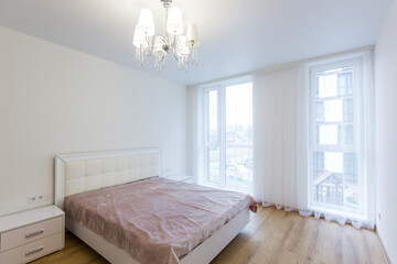The interior of the bedroom in a minimalist style with white walls and a large bed