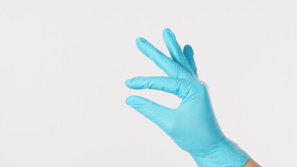 Empty hand and finger do holding gesture and wear blue latex glove on white background.