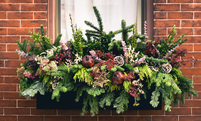 Wide window box arrangement filled with winter seasonal flowers and plants full window