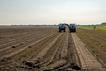 Fototapeta premium Tractors plowing the fields