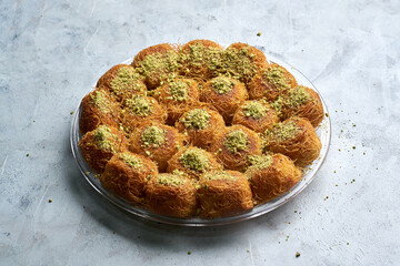 Arabian Traditional Desserts - Cream and cheeses with pistachio flavor and nuts topping on gray background