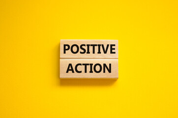 Time to positive action symbol. Wooden blocks with concept words 'Positive action'. Beautiful yellow background. Business and positive action concept. Copy space.