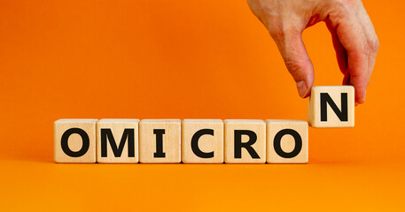 Covid-19 new omicron strain symbol. The concept word Omicron on wooden cubes. Beautiful orange...