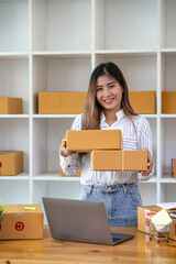 Fototapeta na wymiar Starting Small business entrepreneur SME freelance,Portrait young woman working at home office, BOX,smartphone,laptop, online, marketing, packaging, delivery, e-commerce concept