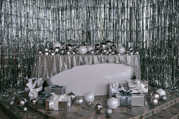 New Year's photo zone: bathroom with balls and gifts, silver tinsel