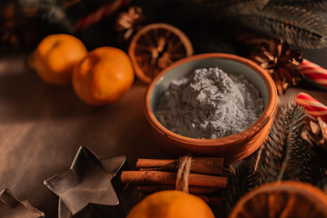 ingredients for Christmas cookies: flour, cinnamon, bakeware, tangerines. New Year and Christmas concept.