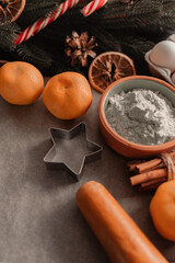 Ingredients for baking Christmas homemade cookies on on parchment. Christmas baking ingredients and tolls for dough preparation. Flour, rolling pin and cookies and spices..Christmas baking concept