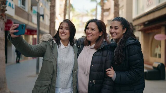 Mother and daughters smiling confident make selfie by the smartphone at street