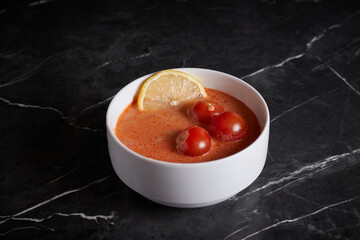 asian soup with meat and seafood, plate close-up on a dark background, vegetables