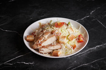 asian salad with meat and seafood, shrimp, plate close-up on a dark background